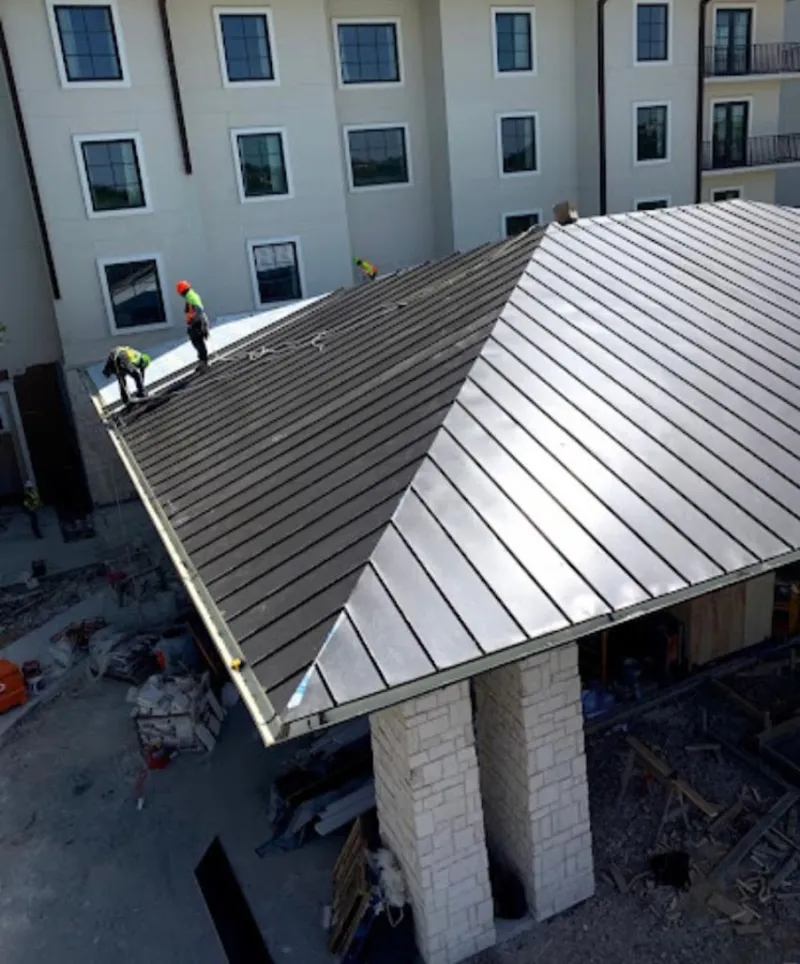 Crew installing standing seam metal roof panels on a commercial project in Deale